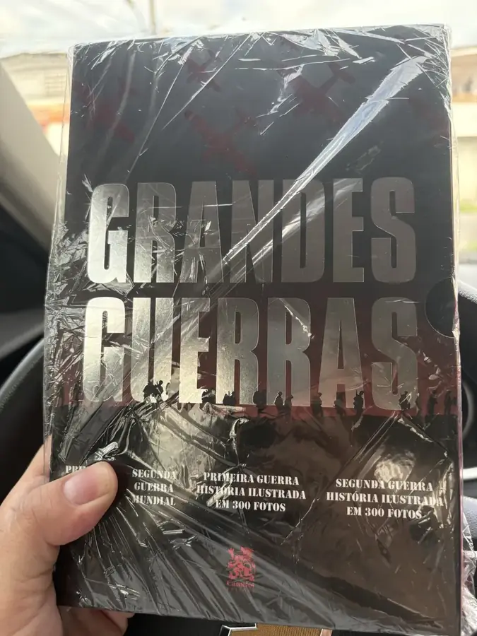 Foto de cliente segurando a caixa Grandes Guerras lacrada